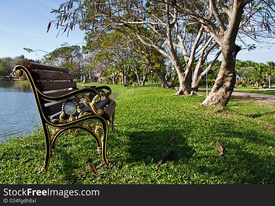 Alloy and wooden bench on the waterside in the public park. Alloy and wooden bench on the waterside in the public park