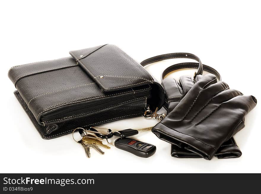 A woman's black purse, driving gloves and a set of keys. Isolatated on white. A woman's black purse, driving gloves and a set of keys. Isolatated on white.