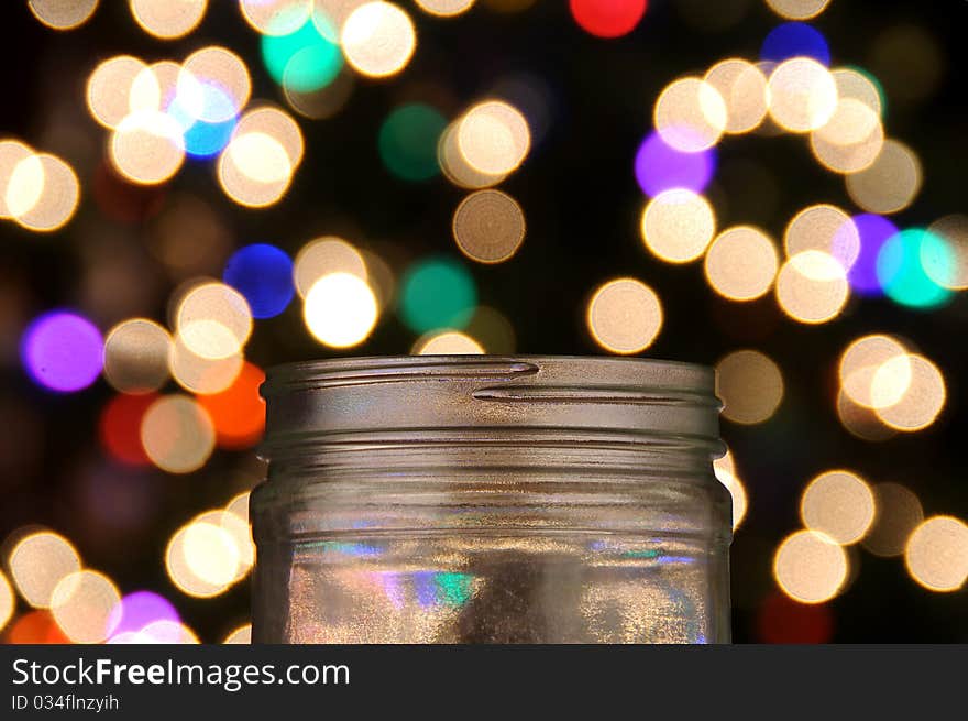 Clear glass jar with magical bokeh dots popping out. Isolated on black background. Clear glass jar with magical bokeh dots popping out. Isolated on black background