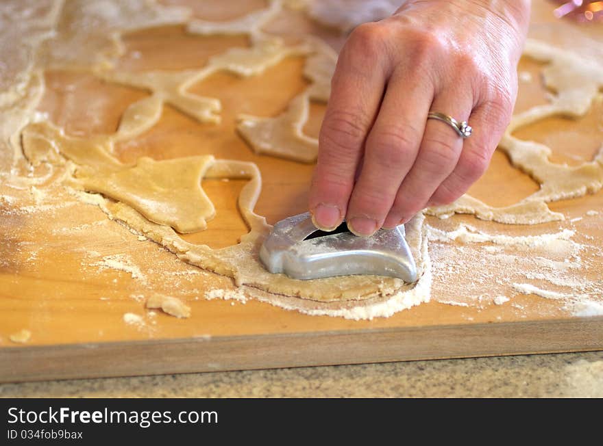 Cutting out Christmas sugar cookies on a cutting board. Cutting out Christmas sugar cookies on a cutting board.