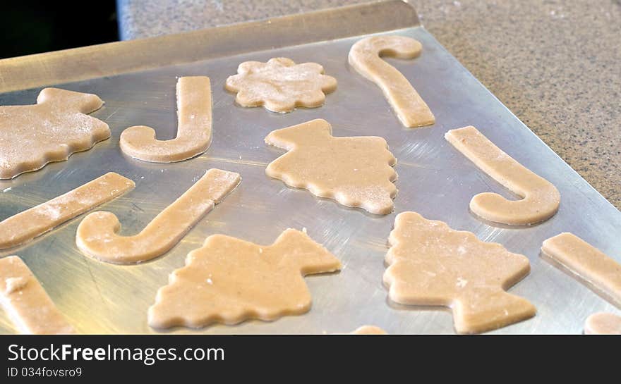 Cutting out Christmas sugar cookies on a cutting board. Cutting out Christmas sugar cookies on a cutting board.