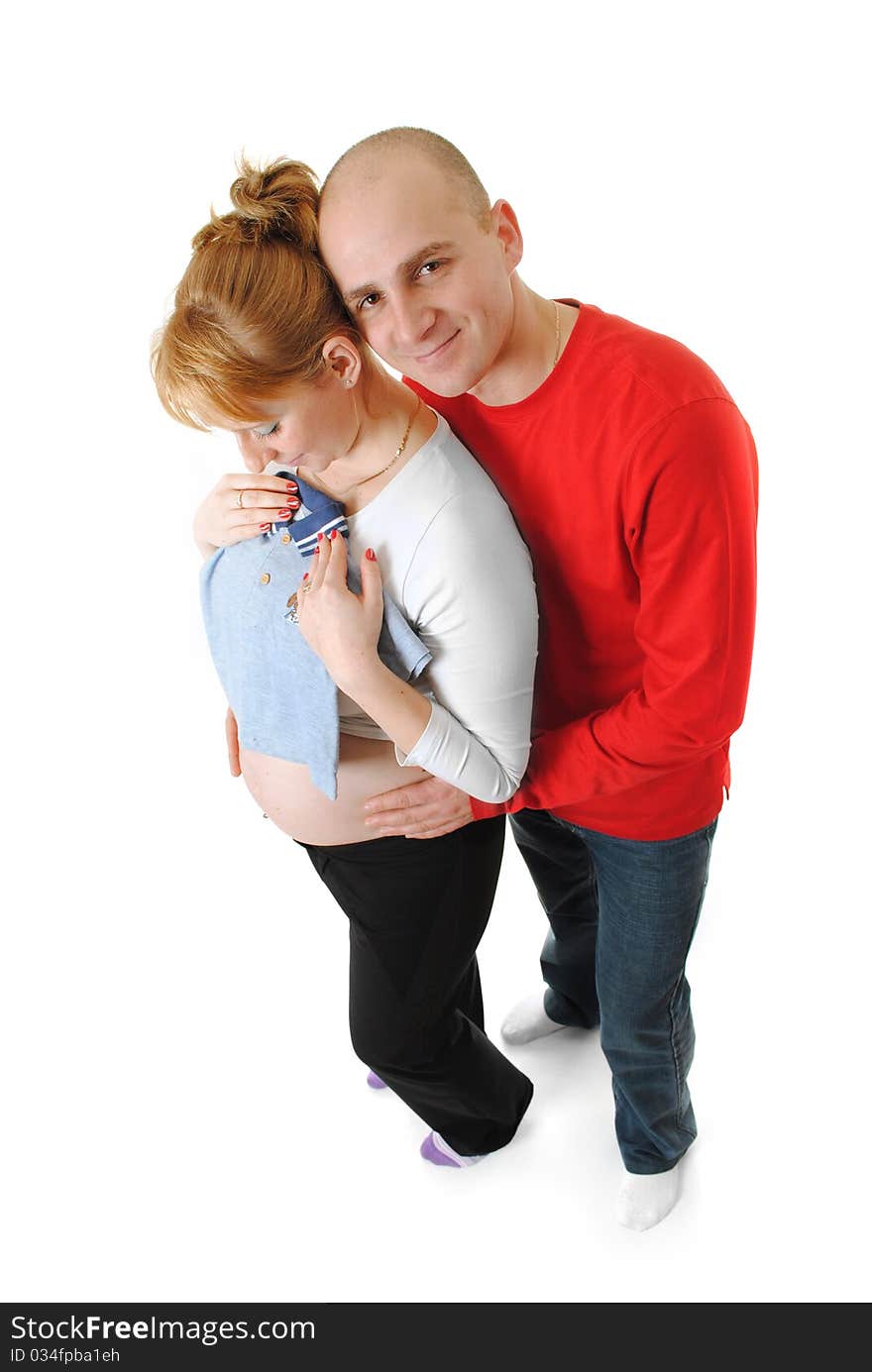 Beautiful young married couple hugging, waiting for a baby. looking for infant clothing. Beautiful young married couple hugging, waiting for a baby. looking for infant clothing