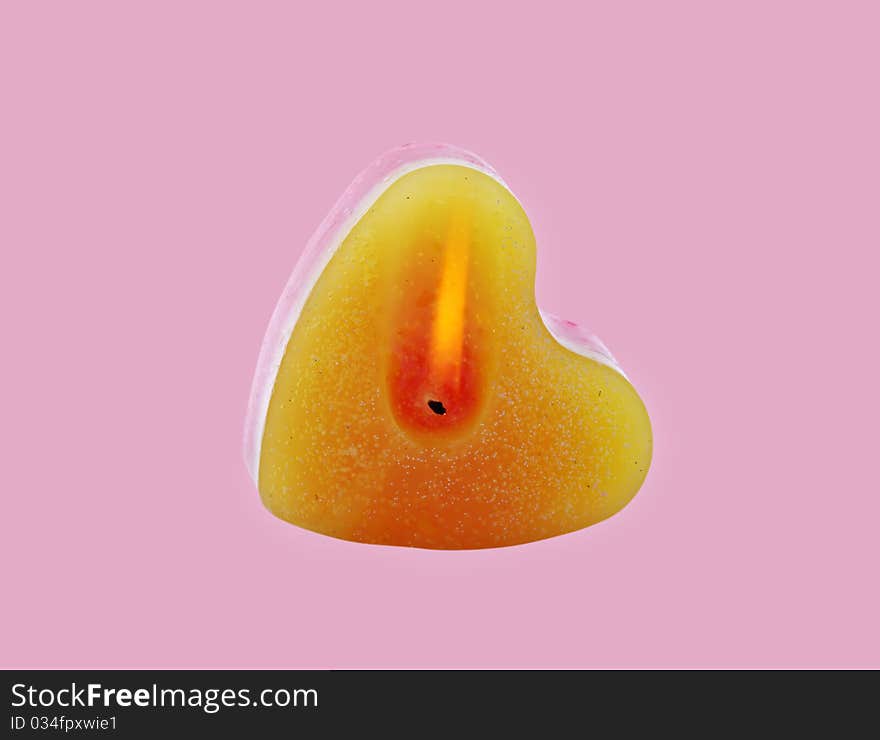 Glowing candle heart shape with clipping paths, isolated on the rose background. Glowing candle heart shape with clipping paths, isolated on the rose background.