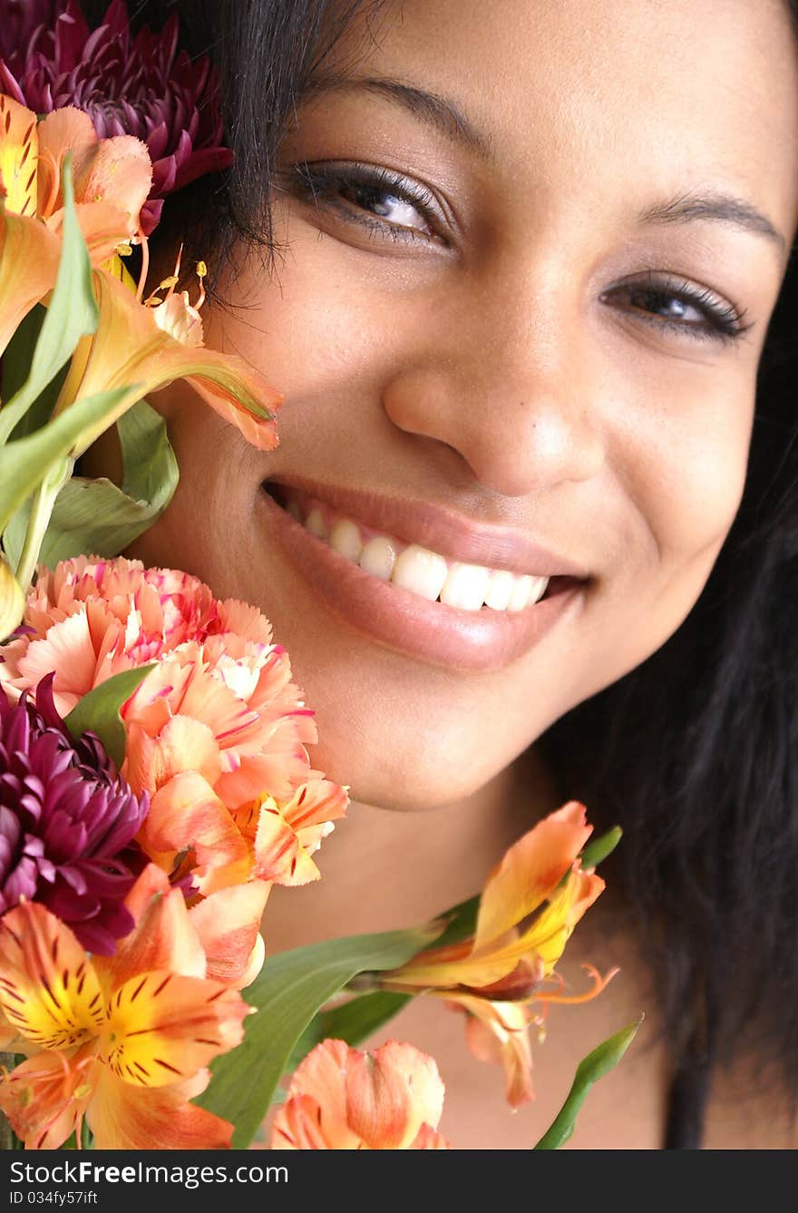 Beautiful young female peers around a fresh bouquet of flowers. Beautiful young female peers around a fresh bouquet of flowers.