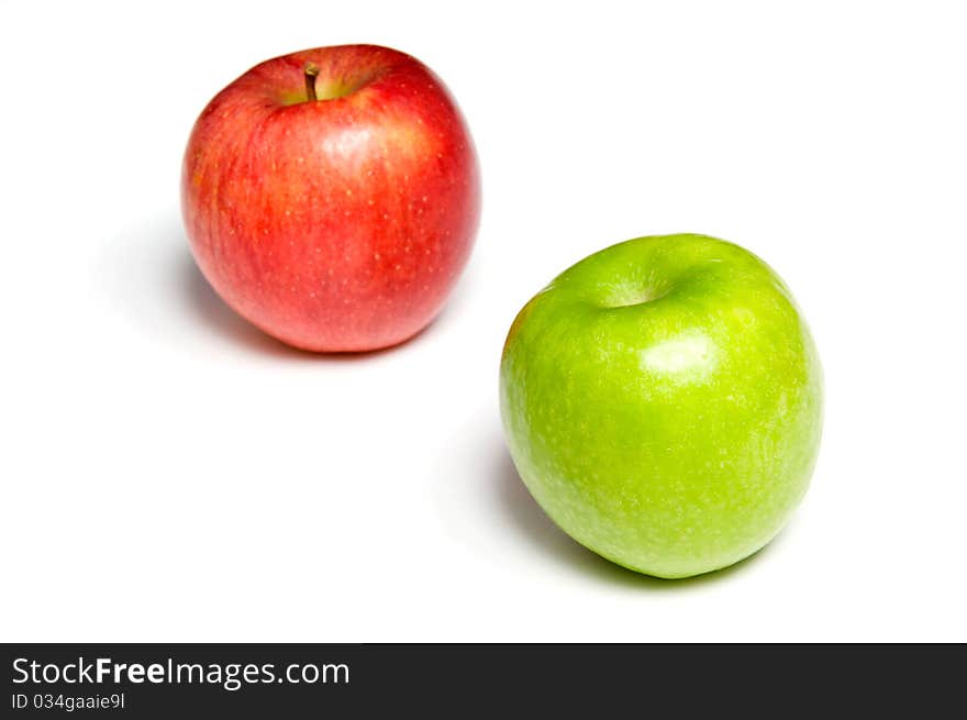 Green and red apples over white - red apple is out of focus