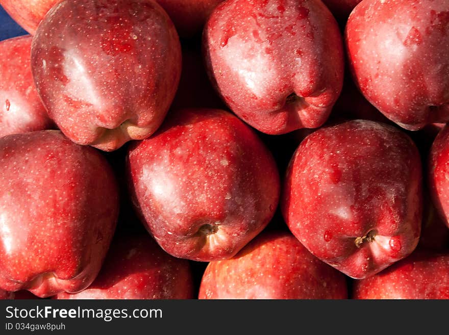 Background of red ripe apples with drops of dew