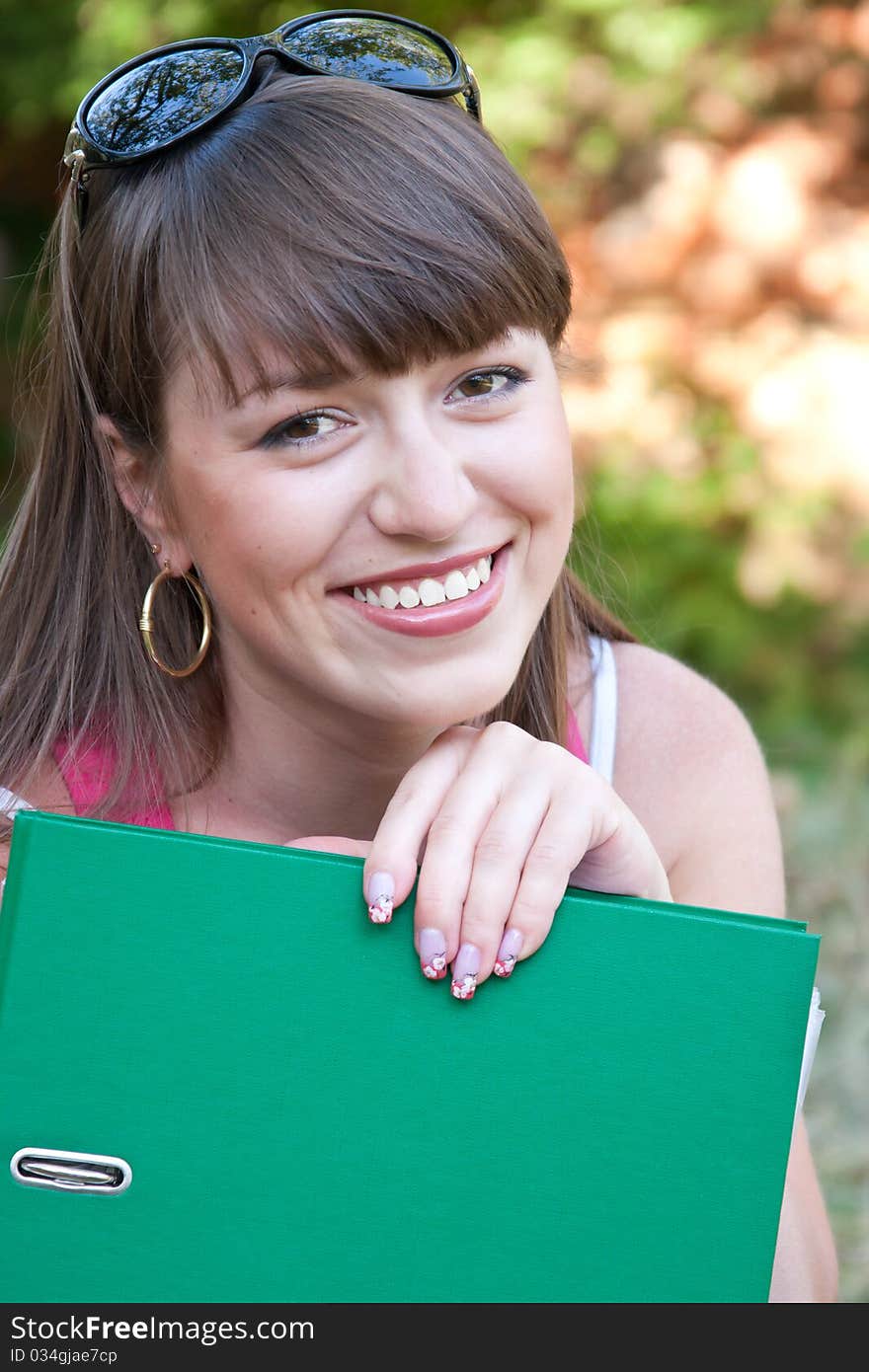 Young beautiful student with the unfolded folder. Young beautiful student with the unfolded folder.