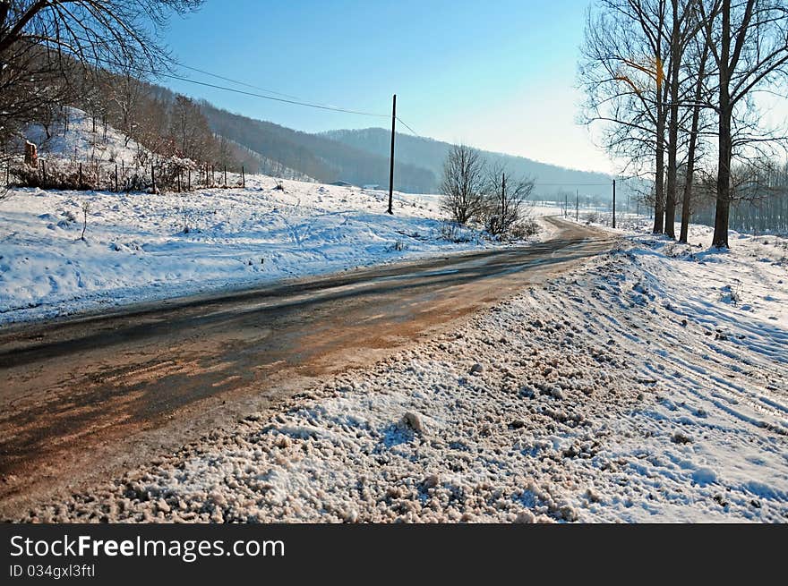 Winter traffic: curved road partially covered by snow. Winter traffic: curved road partially covered by snow