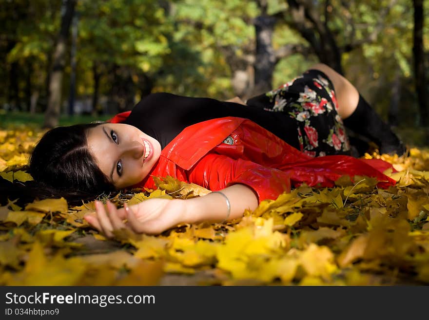 Young woman in autumn park on ground