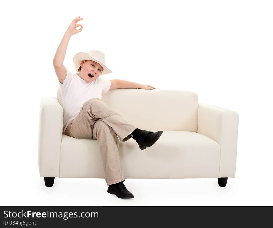 Portrait of a boy wearing a hat on a couch showing sign Ok