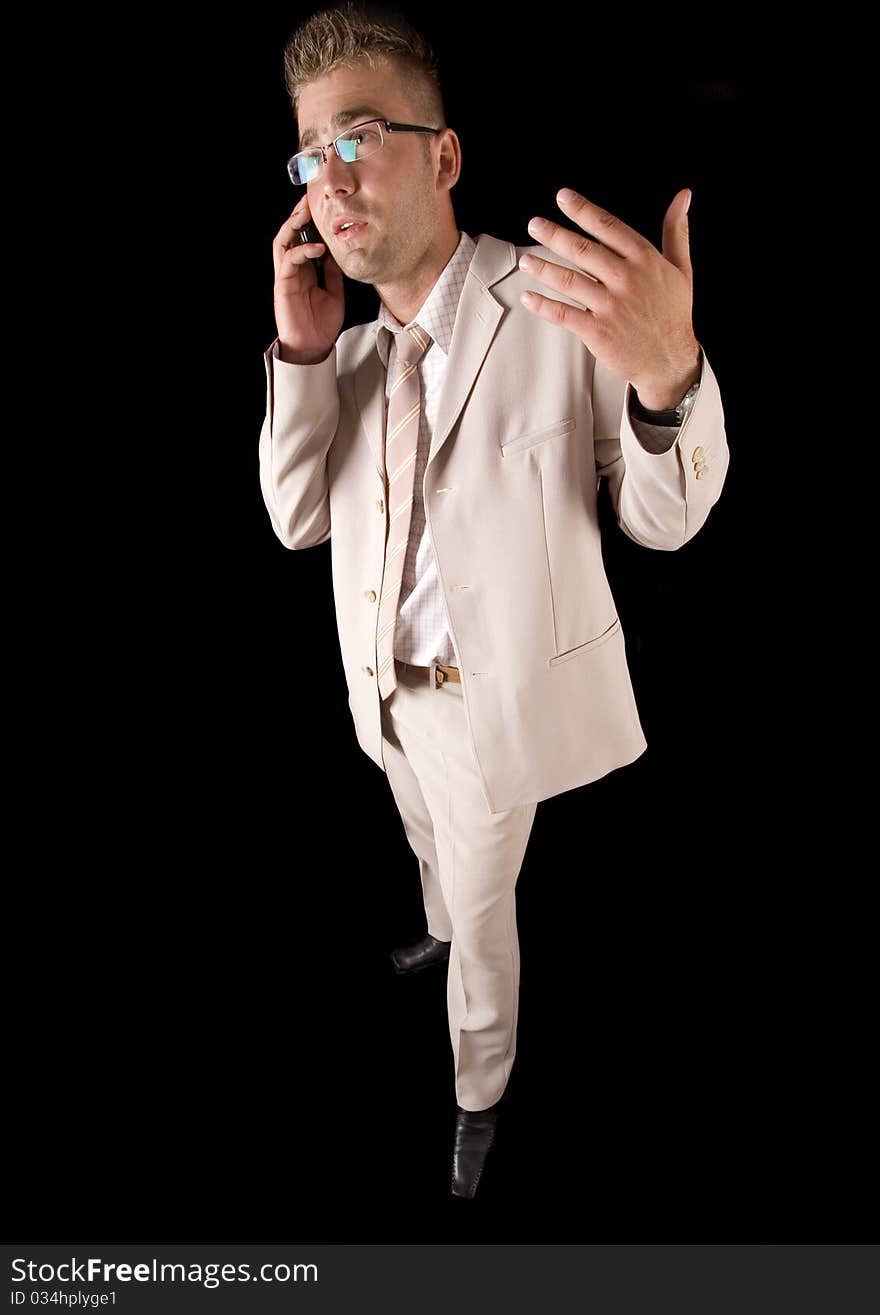 Elegant man standing on a black background. Businessman talking on the phone