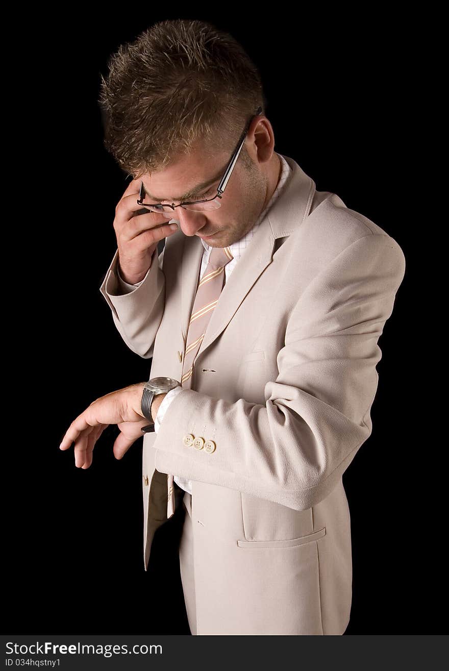 Elegant man standing on a black background. Businessman talking on the phone