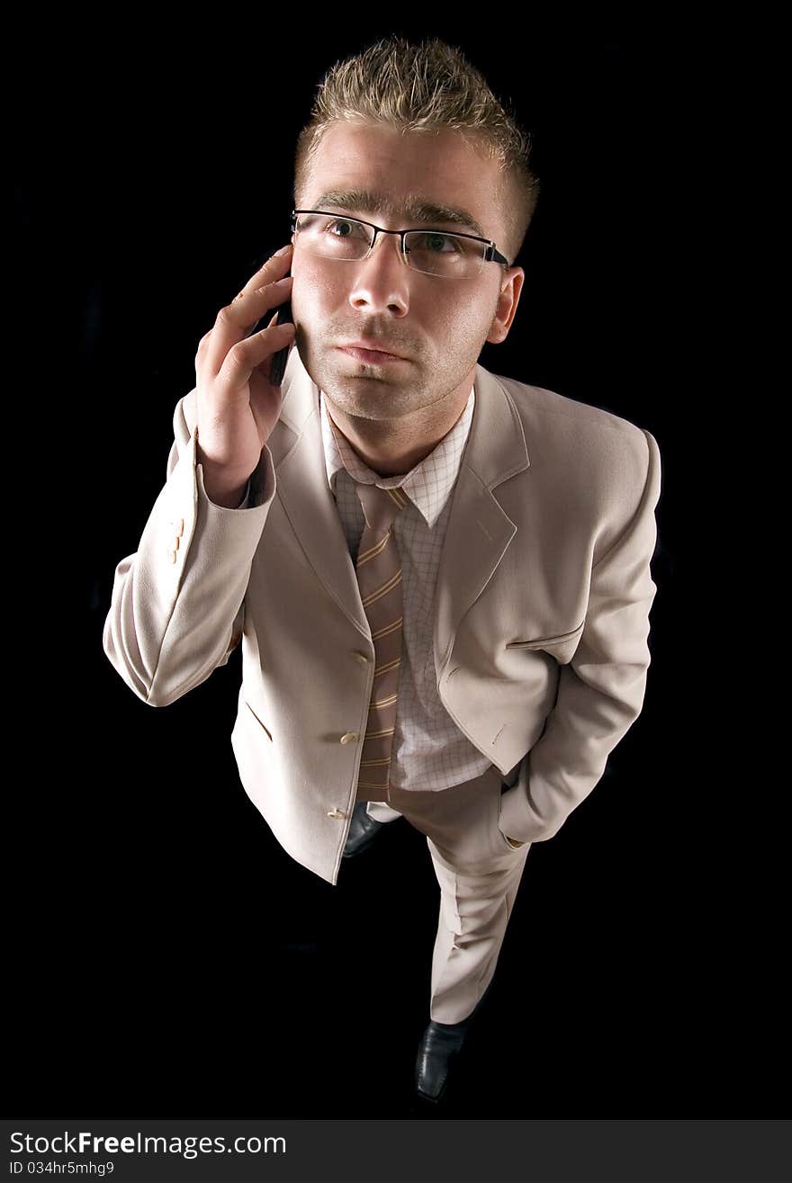 Elegant man standing on a black background. Businessman talking on the phone