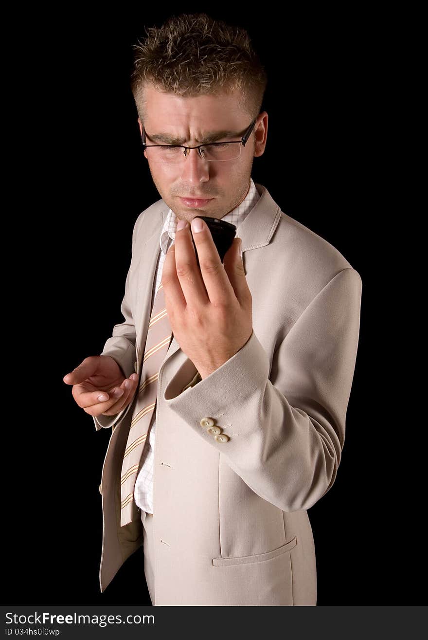 Elegant man standing on a black background. Businessman talking on the phone