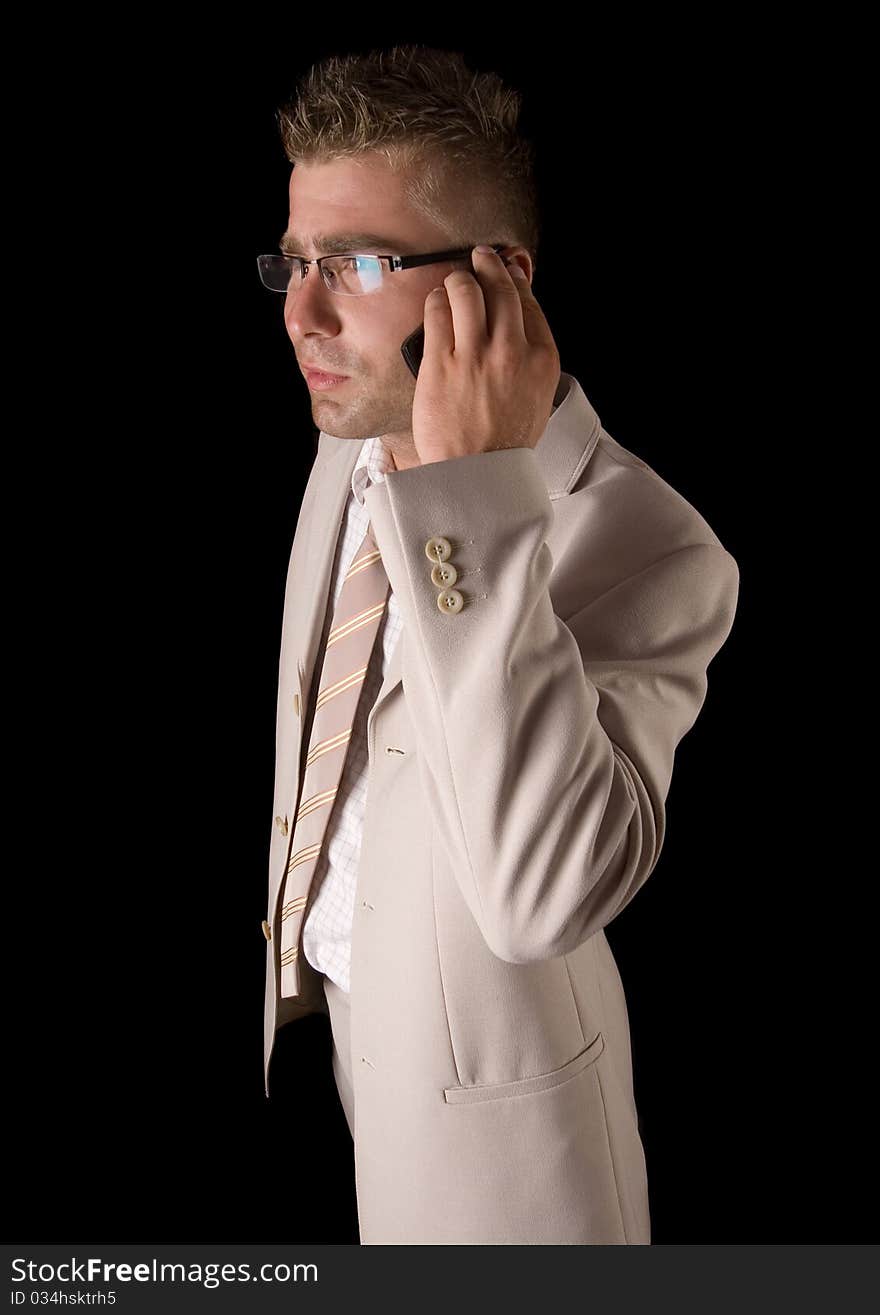 Elegant man standing on a black background. Businessman talking on the phone