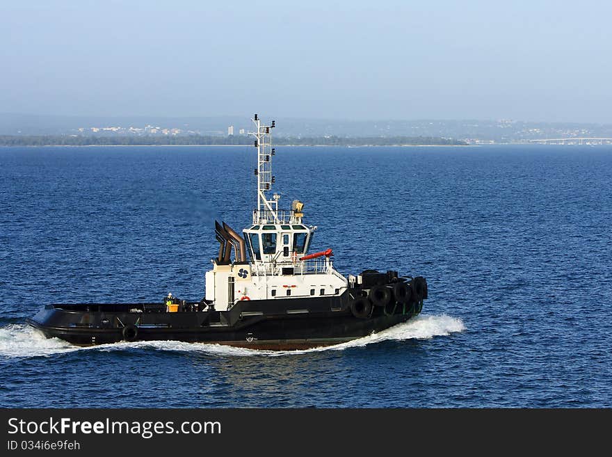 Sea tugboat under power in harbour.