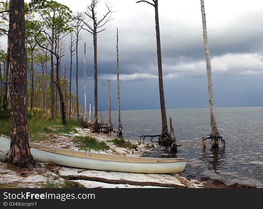 Canoe on shoreline with storm approaching. Canoe on shoreline with storm approaching