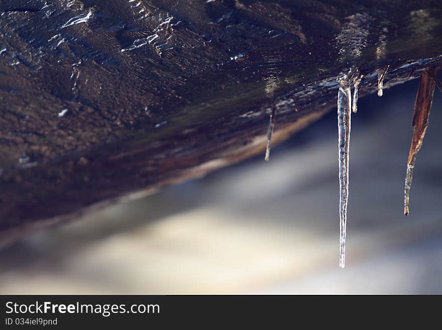 Ice hanging from wood beam on a bridge