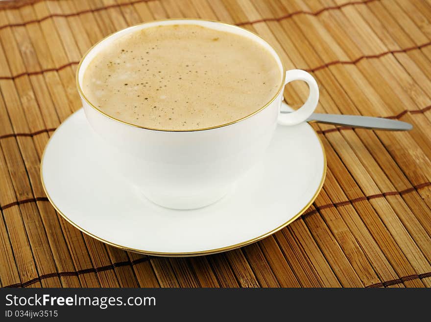 Classic white cup cappuccino and saucer with teaspoon. Closeup