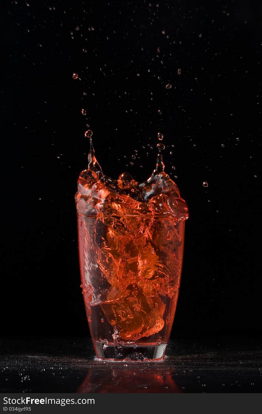 Ice falling in the juice and making a splash. Ice falling in the juice and making a splash.