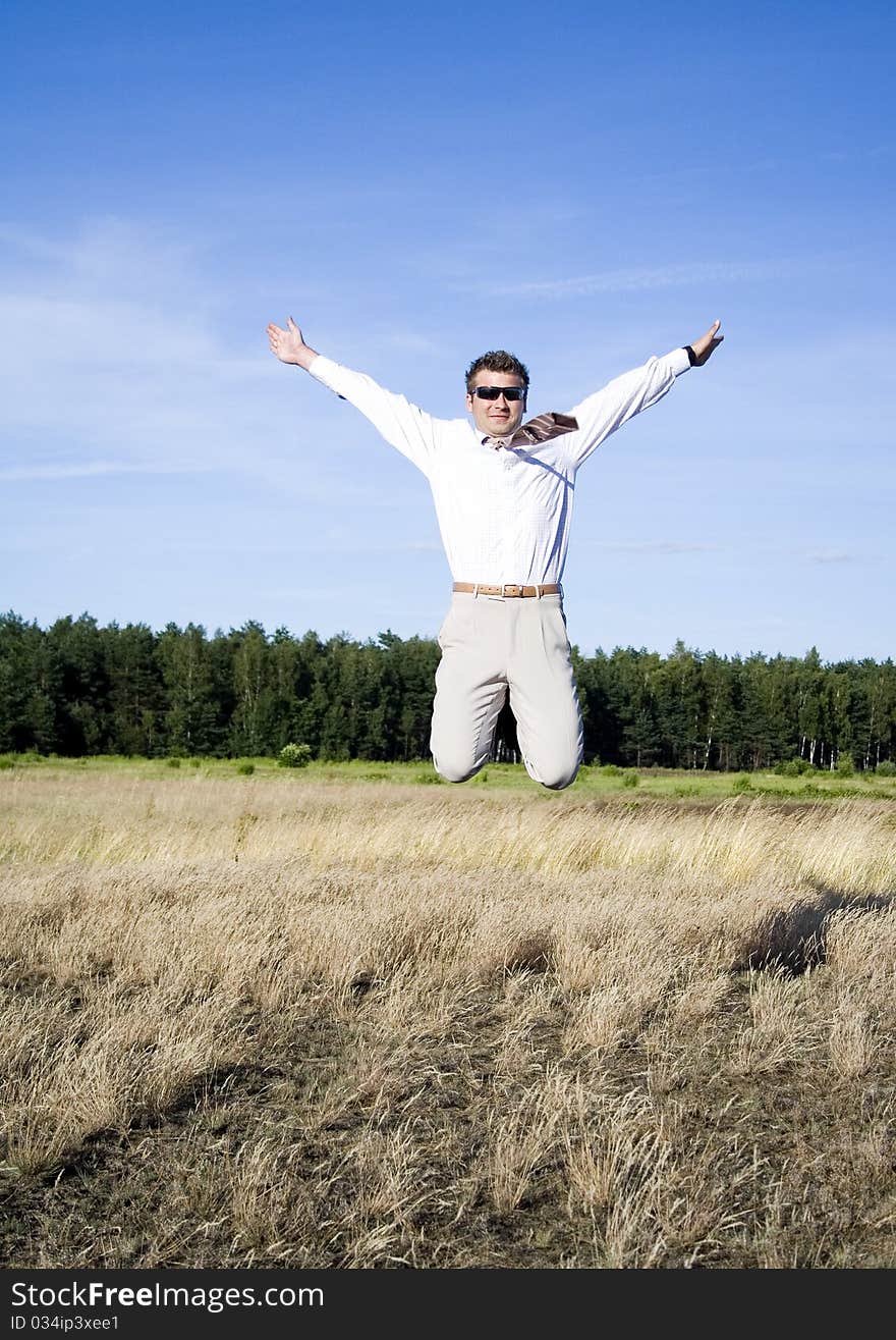 Businessman dressed in an elegant suit, jumping with joy in nature. Businessman dressed in an elegant suit, jumping with joy in nature