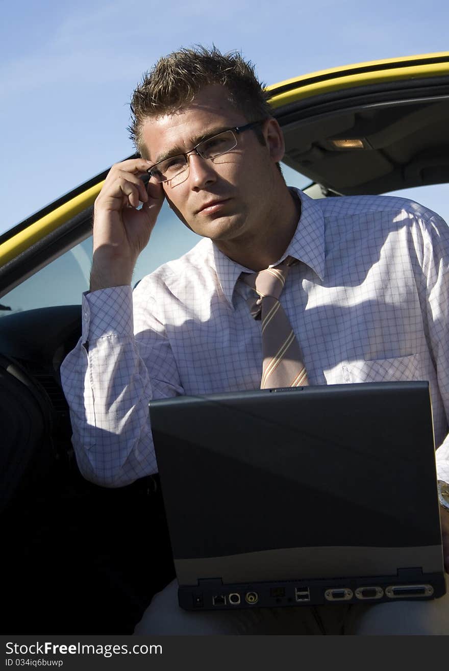 Elegant businessman working on his laptop in nature.