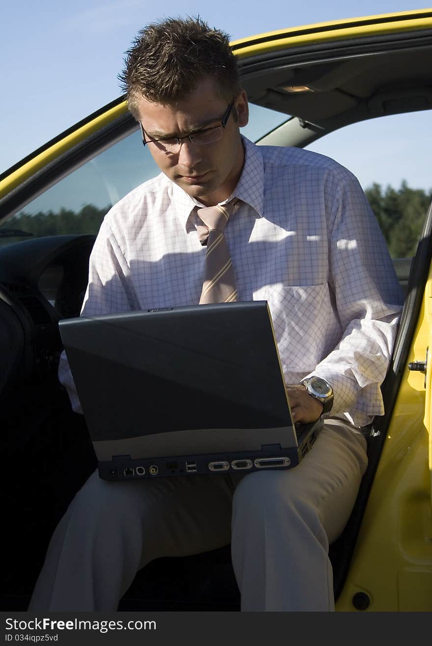 Elegant businessman working on his laptop in nature.