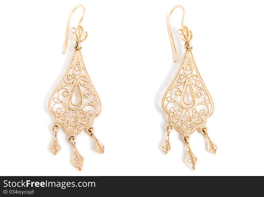 Graceful gold earrings, is isolated on a white background