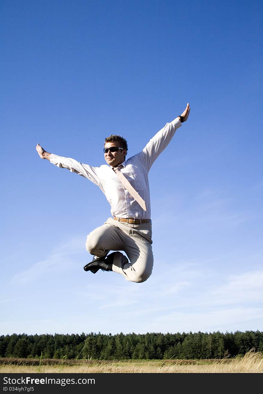 Businessman dressed in an elegant suit, jumping with joy in nature. Businessman dressed in an elegant suit, jumping with joy in nature