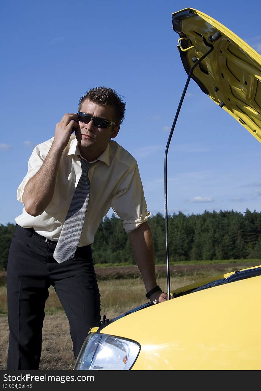 A businessman dressed in a smart suit standing on grass and talking on mobile phone. A businessman dressed in a smart suit standing on grass and talking on mobile phone.