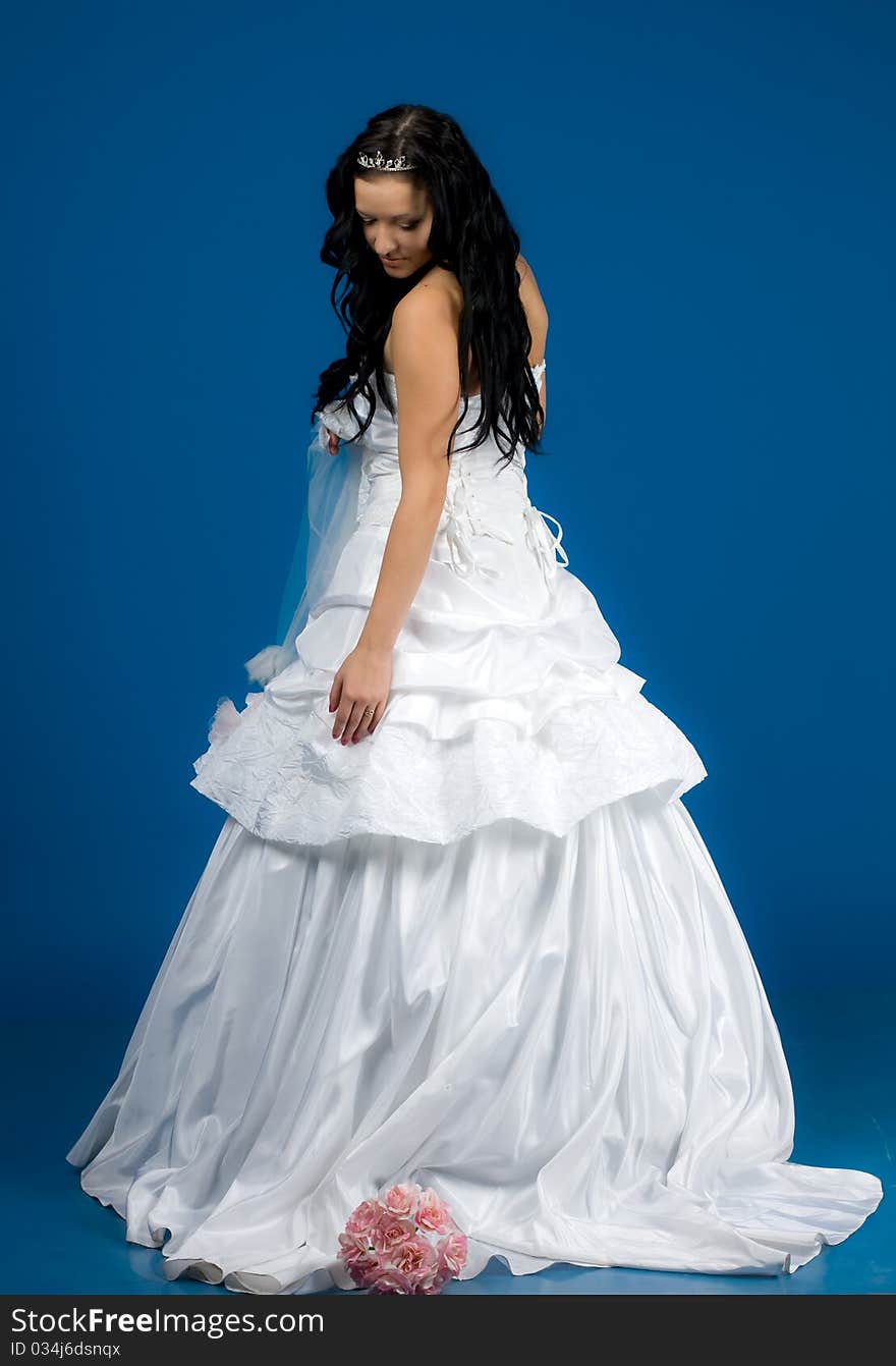 Portrait of beautiful happy bride in a wedding dress on blue background studio shot. Portrait of beautiful happy bride in a wedding dress on blue background studio shot