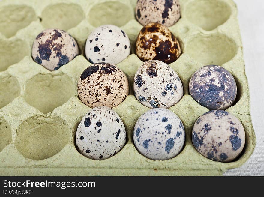 Cute few quail eggs in a carton