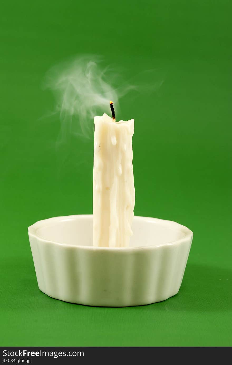 Unlit candle Spotlight on green background