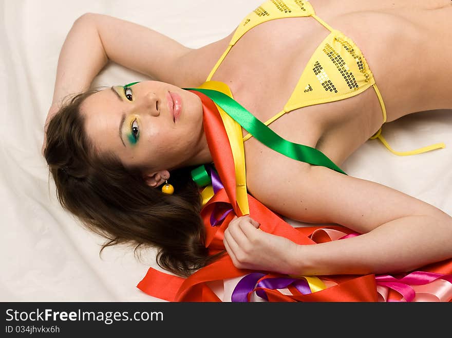 girl with colourful ribbons in studio on red background. girl with colourful ribbons in studio on red background