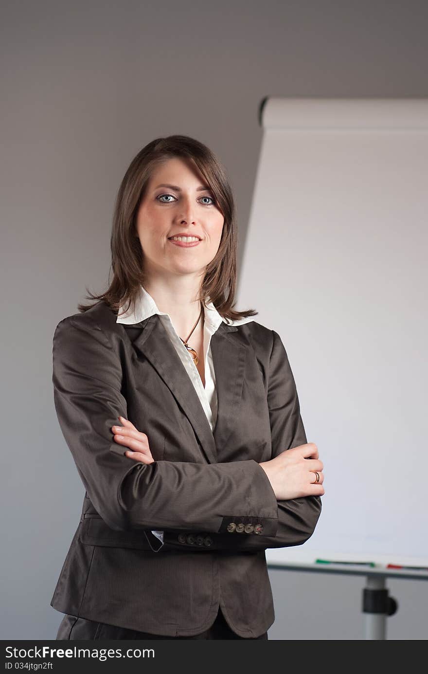 Young business woman standing in front of a flipchart. Young business woman standing in front of a flipchart