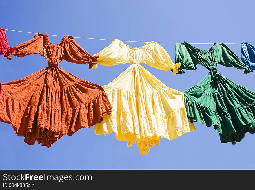 Several Colorful Dresses against a blue sky