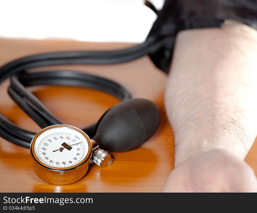 Close view of a blood pressure gauge at a man`s am. Close view of a blood pressure gauge at a man`s am