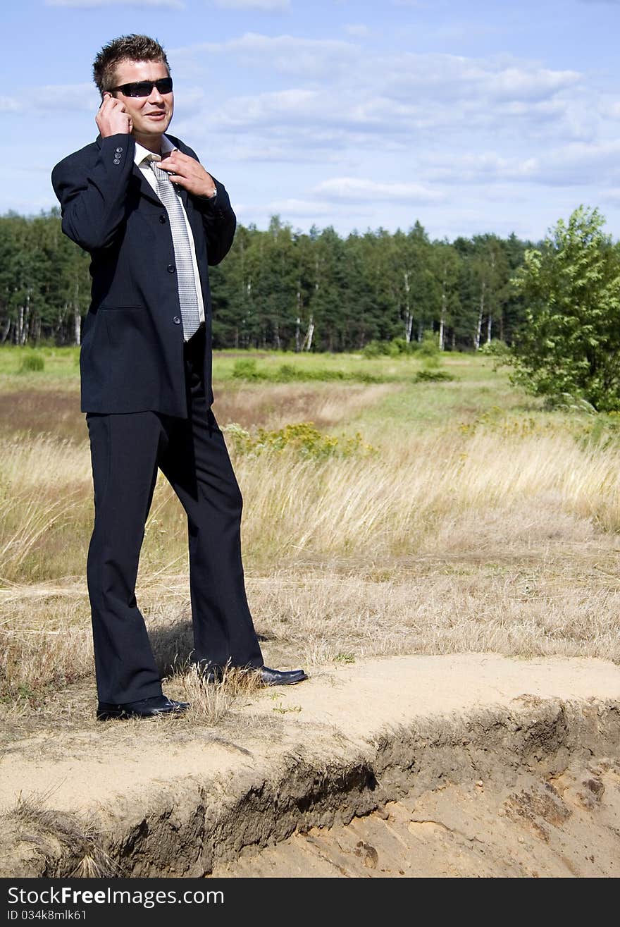 A businessman dressed in a smart suit standing on grass