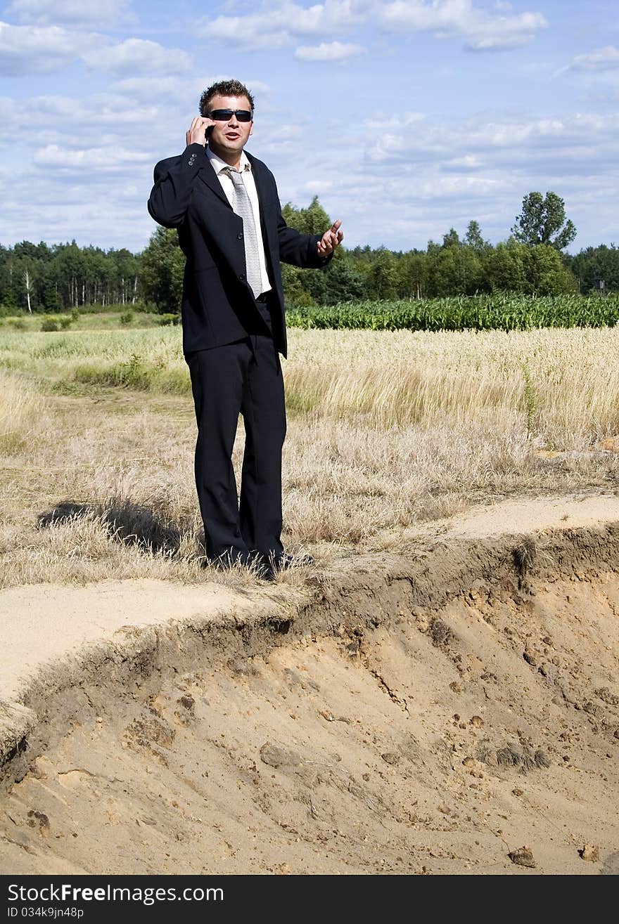 A businessman dressed in a smart suit standing on grass