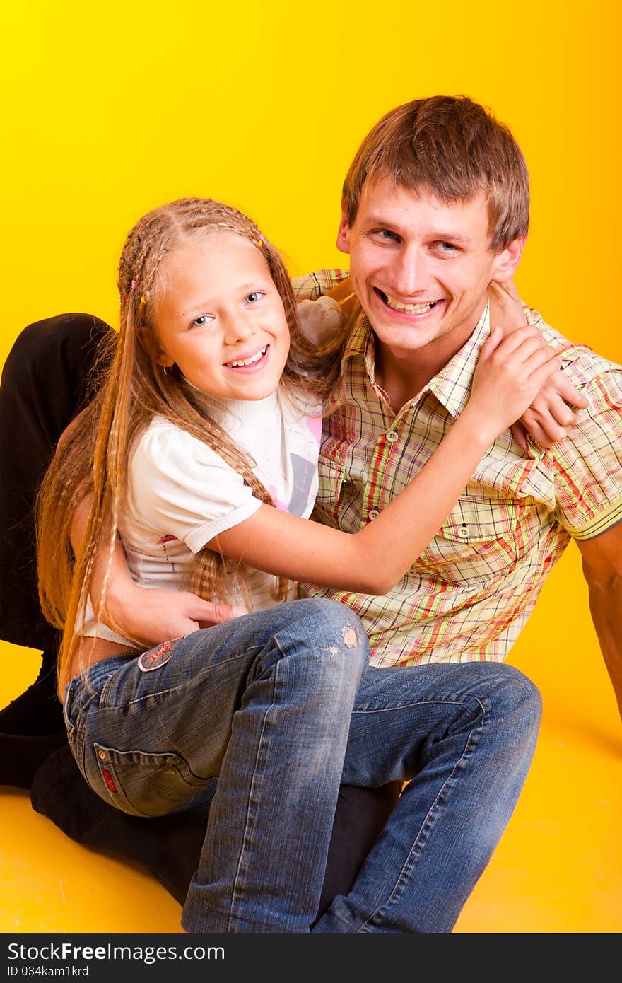 Happy dad with daughter on a yellow background