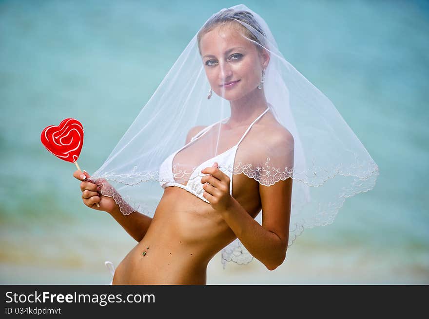 Beautiful girl holding a lollipop on the beach. Beautiful girl holding a lollipop on the beach