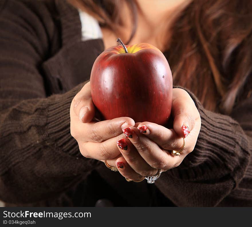 Female hands holding ripe red apple. Female hands holding ripe red apple.