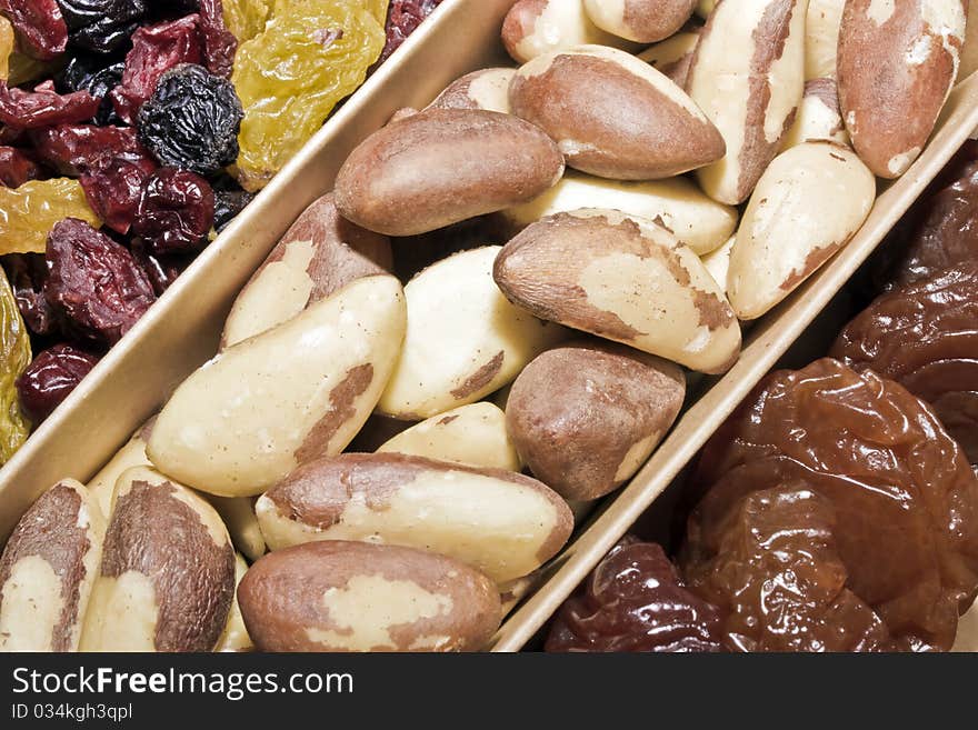 A close up of a box of dried fruit and brazil nuts. A close up of a box of dried fruit and brazil nuts