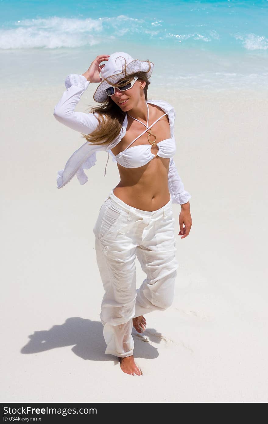 A girl is in white on a beach. A girl is in white on a beach