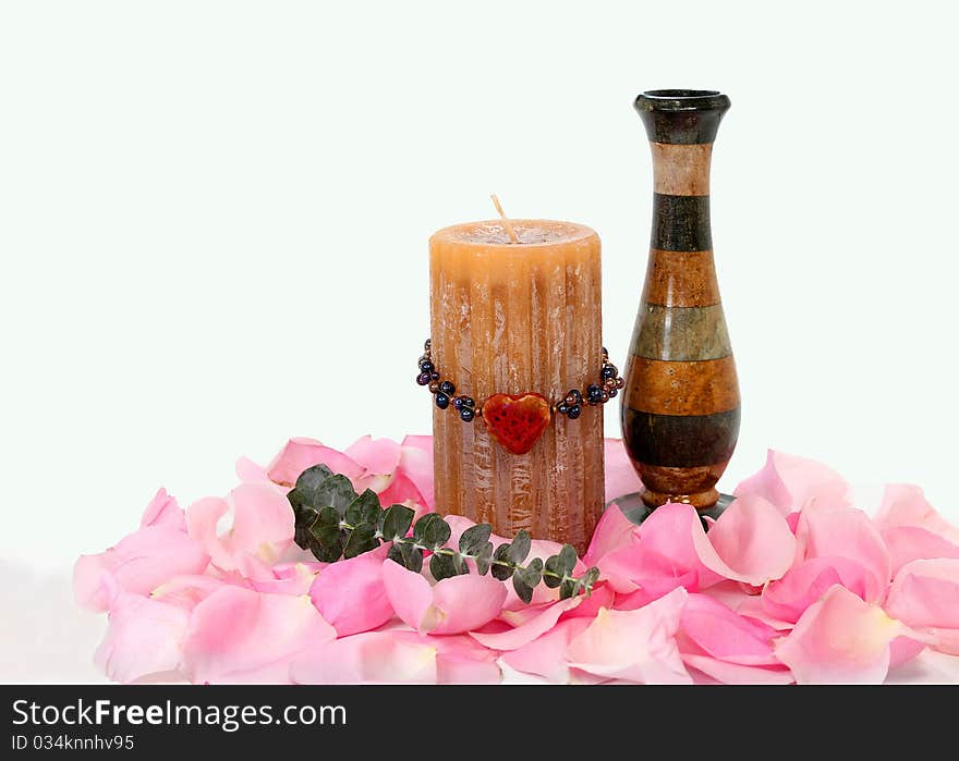 Candle and vase with rose petals and heart beads; on white background. Candle and vase with rose petals and heart beads; on white background.