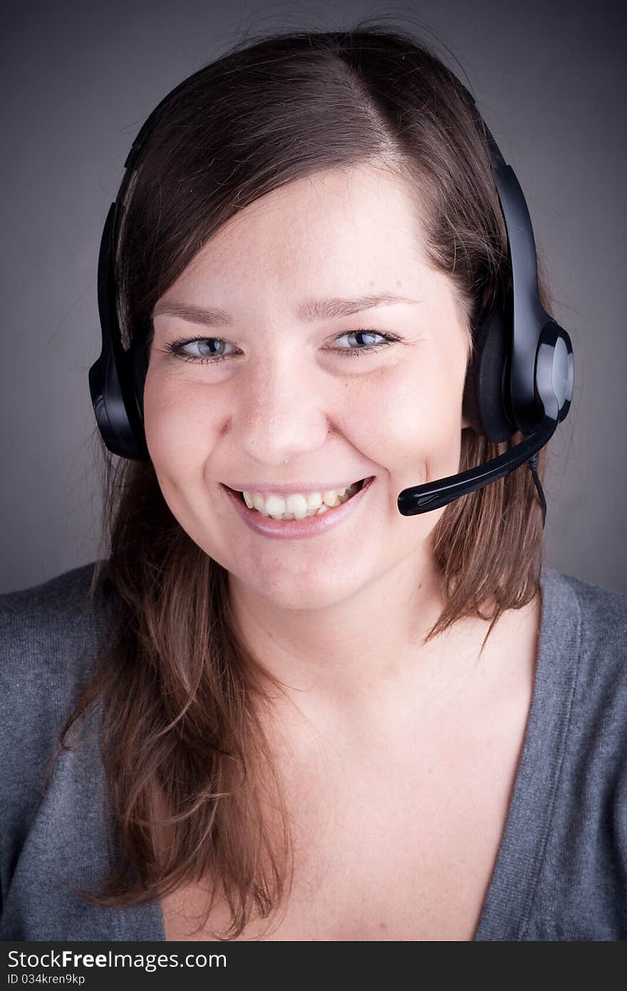 Studio picture from a young and beautiful callcenter agent, grey background