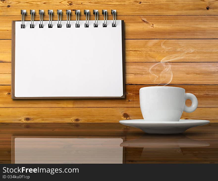 White cup of hot coffee on table and White note paper on wood wall. White cup of hot coffee on table and White note paper on wood wall