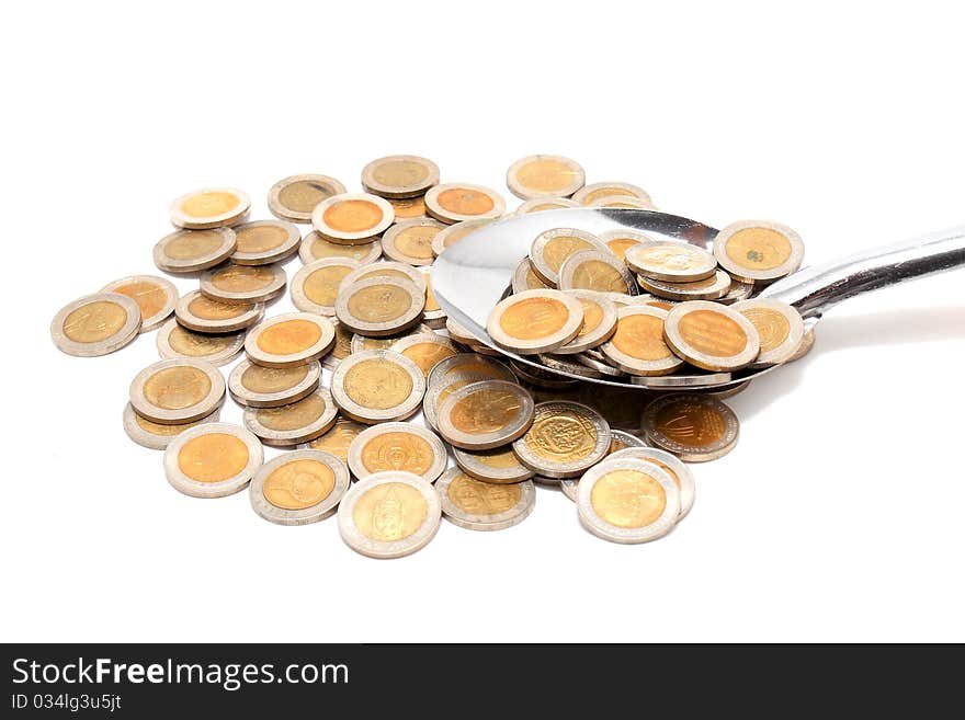 Coins and the spoon in a plate on a white background. Coins and the spoon in a plate on a white background