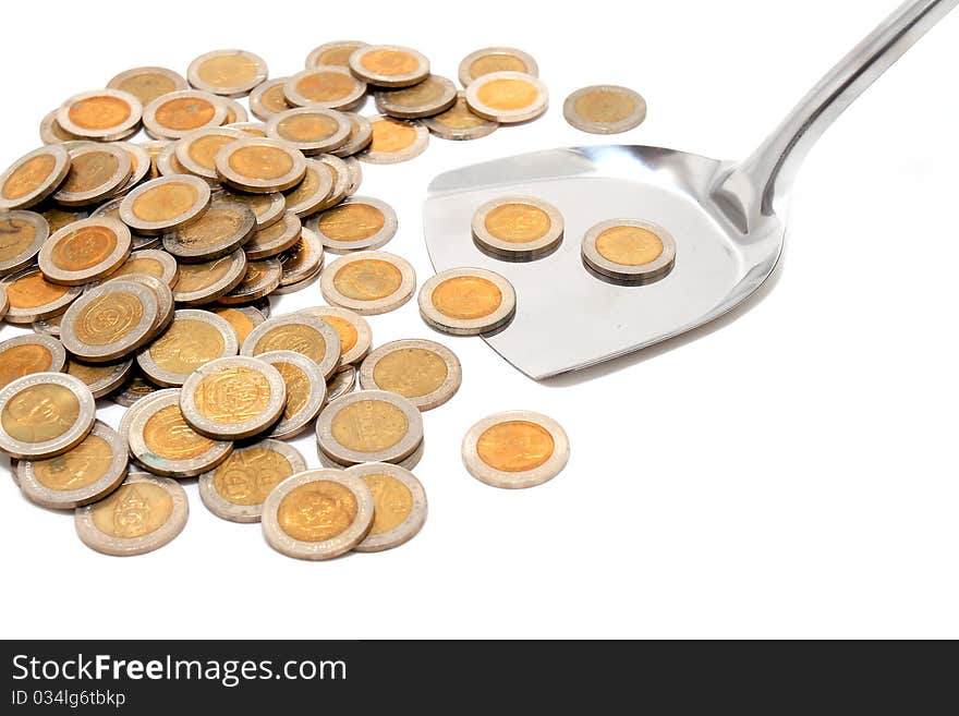 Coins and the spoon in a plate on a white background