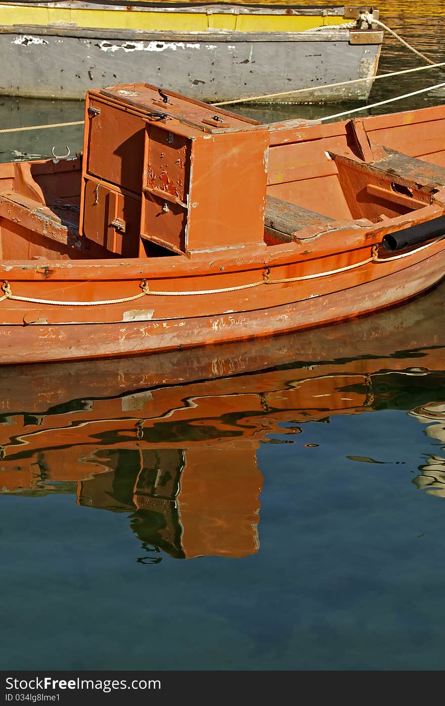 Red fishing boat reflection on water